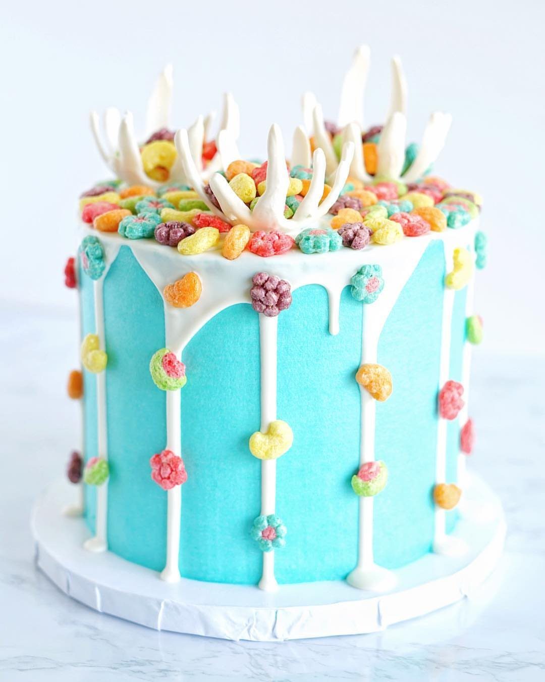 21 Cake Decoration Ideas for Every Skill Level 12 Blue frosted cake topped with colorful loop cereal and white chocolate shards.