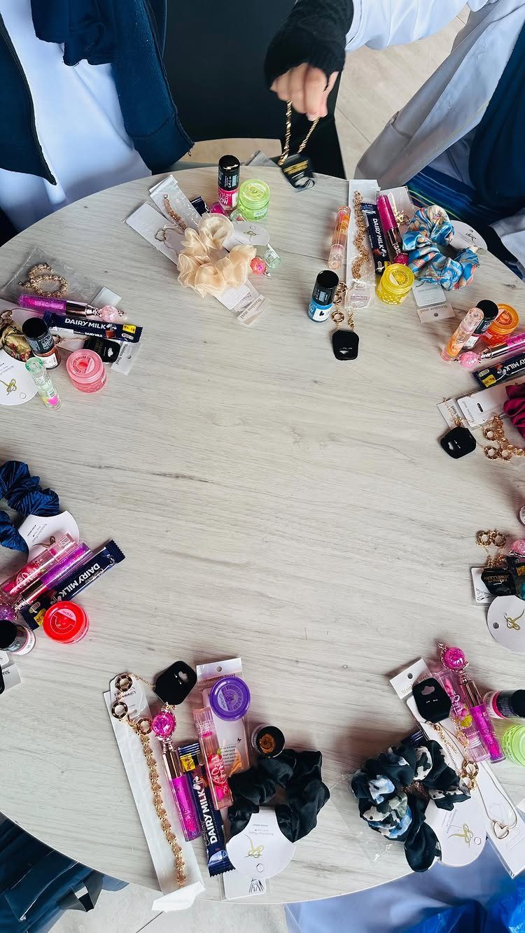 Small colorful gifts and accessories arranged in a circle on a white table.