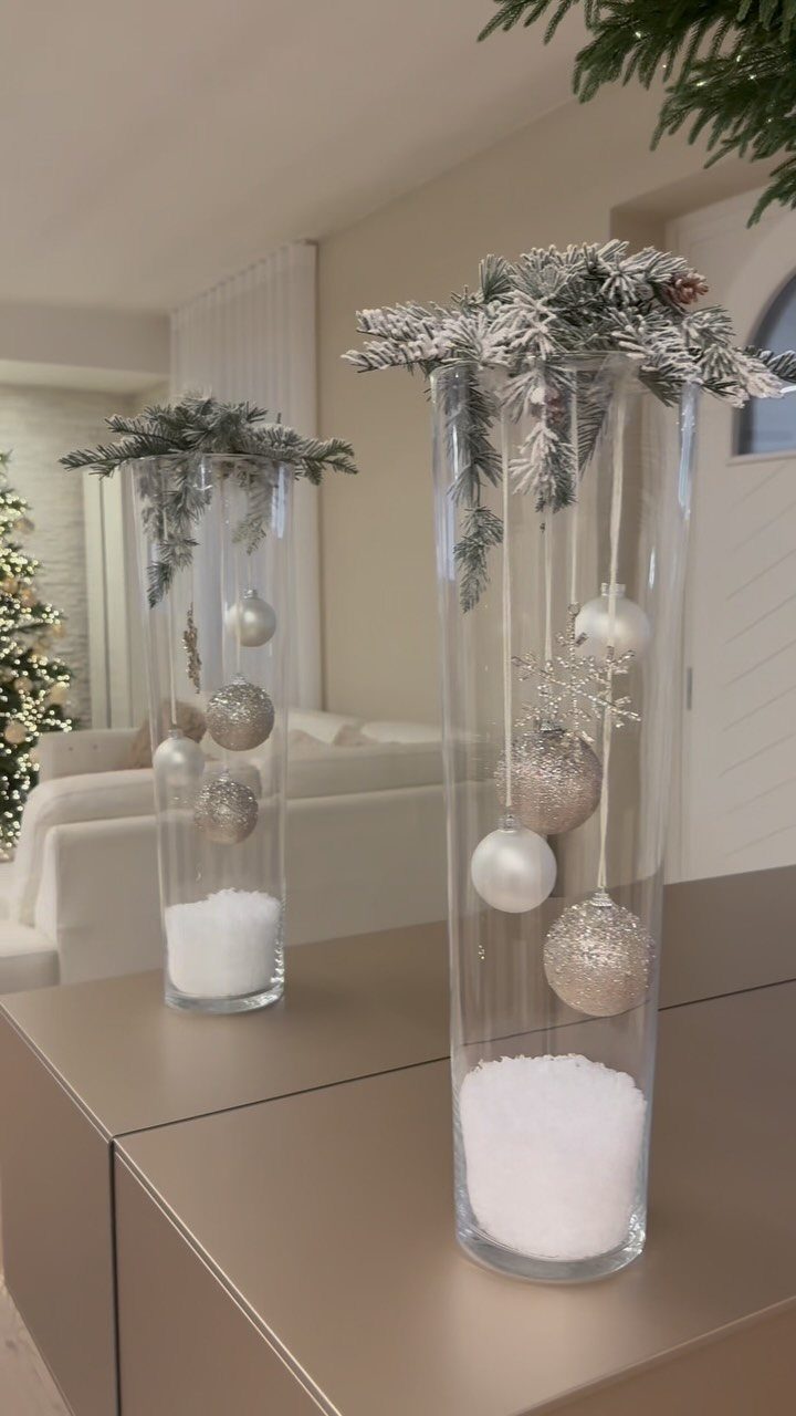 36 Christmas Decor Ideas for the Home: Doors, Tables, Trees & More 33 Two tall glass vases with faux snow, pine branches, and silver ornaments.