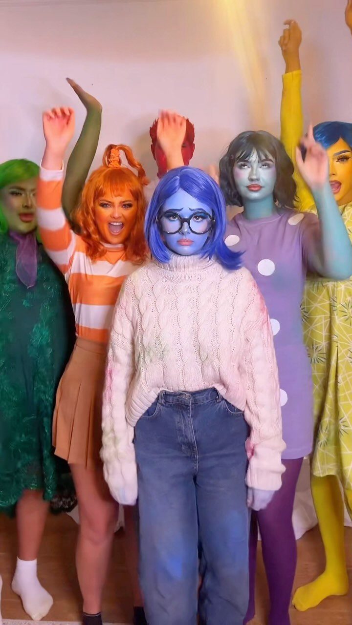 Five people wearing colorful makeup and costumes as emotions from Inside Out.