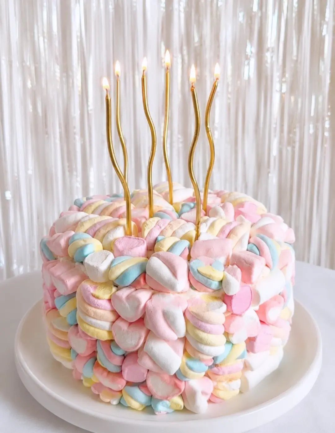 21 Cake Decoration Ideas for Every Skill Level 16 Cake covered in pastel twisted marshmallows with five lit gold wavy candles.