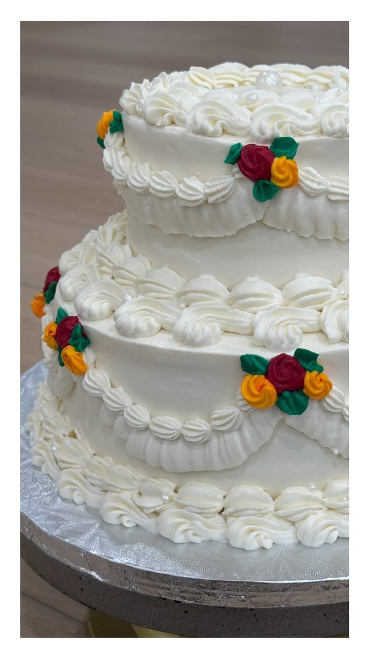 White Cake Decoration: 9 Elegant Finishes for Any Celebration 10 Multi-tiered white cake with piped frosting, colorful roses, and small white pearl accents.