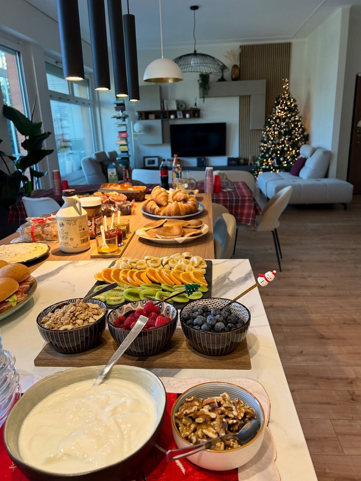 22 Christmas Party Themes for Adults Ideas (2026) 13 Brunch spread with fruit, yogurt, and pastries in a room with a Christmas tree