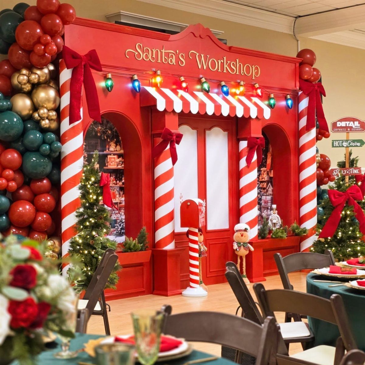 22 Christmas Party Themes for Adults Ideas (2026) 7 Santa's Workshop themed party setup with red facade, candy cane pillars, and balloons.