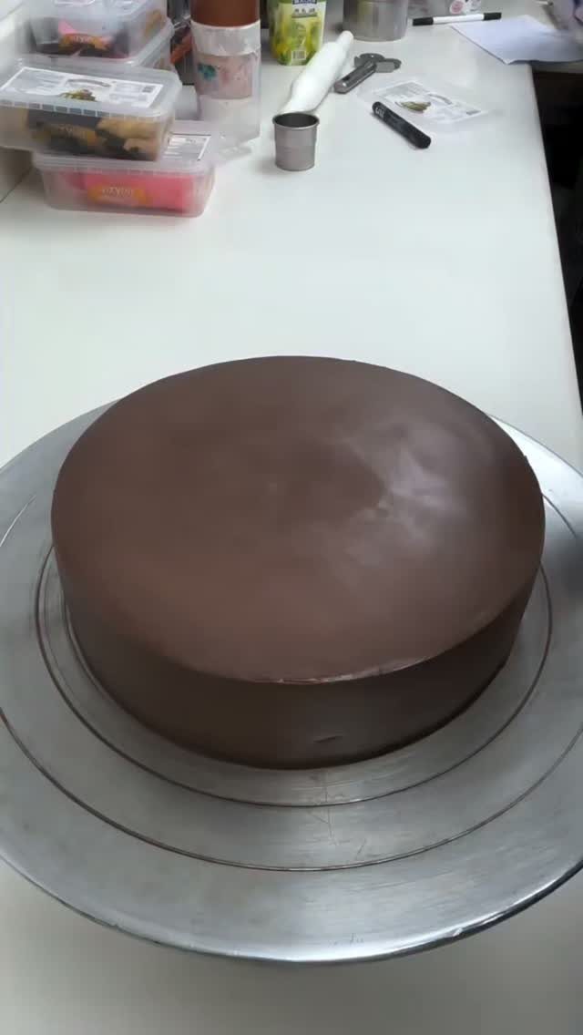 21 Cake Decoration Ideas for Every Skill Level 21 Chocolate glazed round cake on a silver rotating cake stand on white counter