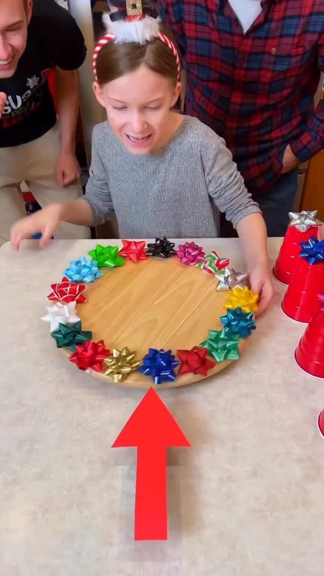 Girl standing behind a wooden circular board decorated with colorful Christmas bows.