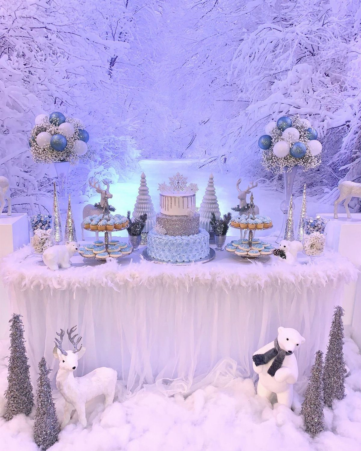 22 Christmas Party Themes for Adults Ideas (2026) 3 White and silver dessert table with cake and figurines in a snowy forest